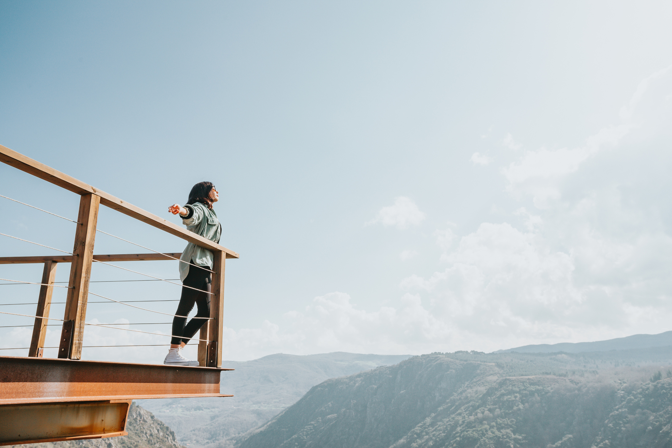 A Woman Standing on a Mountain View Deck